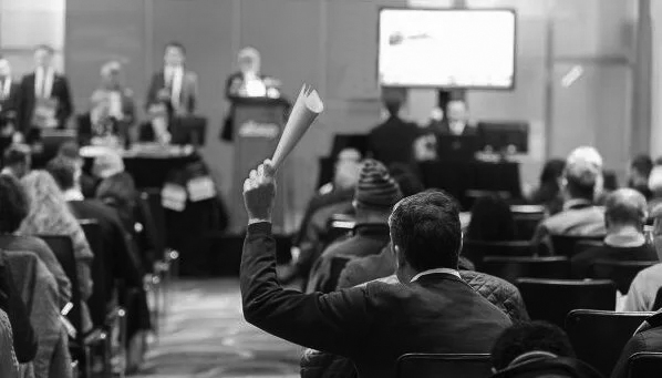 Property auction room with bidders - auction finance for commercial and residential property purchases